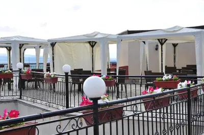 a patio with tables and white tents with flowers at Villa on the Black Sea in Sunny Beach