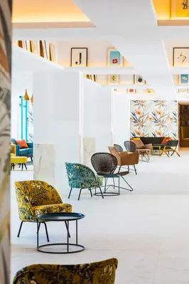 a gallery with chairs and tables in a room at Zefir Hotel in Sunny Beach