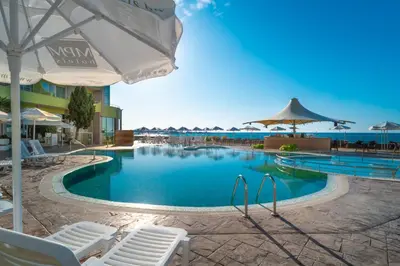 a large swimming pool with chairs and umbrellas at MPM Hotel Arsena - Ultra All Inclusive in Nesebar