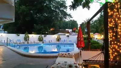 a swimming pool with lights on a white wall at Hotel Lotos in Kiten