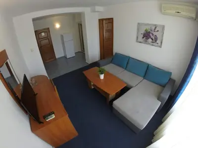 a living room with a couch and a table at Hotel Lotos in Kiten