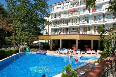 a hotel with a swimming pool in front of a building at Hotel Lotos in Kiten