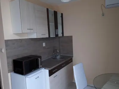a small kitchen with a microwave and a sink at Apart Hotel Ravda in Ravda