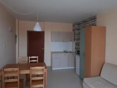 a kitchen with a table and a dining room at Apart Hotel Ravda in Ravda