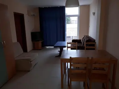 a living room with a table and chairs and a window at Apart Hotel Ravda in Ravda