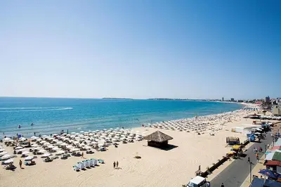 a beach with a lot of umbrellas and the ocean at Barcelo SeaView Apartment in Sunny Beach