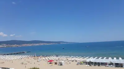 a beach with many umbrellas and people on the beach at Apartment Sianie в центъра на Слънчев бряг, само на няколко крачки от плажа in Sunny Beach