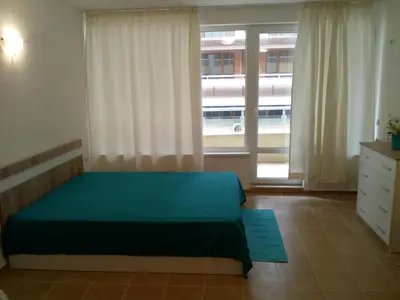 a bedroom with a green bed and a window at Studio Zlatina in Pomorie