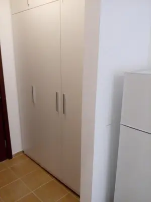 a kitchen with white cabinets and a refrigerator at Studio Zlatina in Pomorie