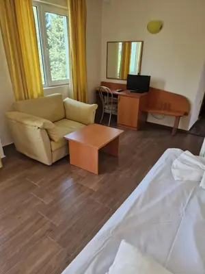 a living room with a couch and a desk with a computer at Family Hotel Romantik in Sunny Beach