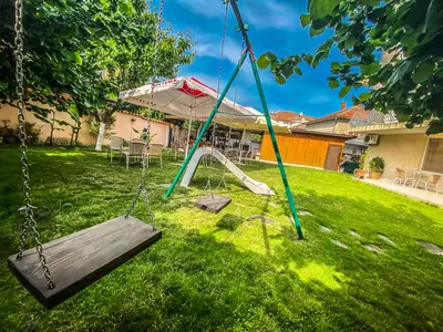 a swing in the yard of a house at Vanessa Family Hotel in Ravda