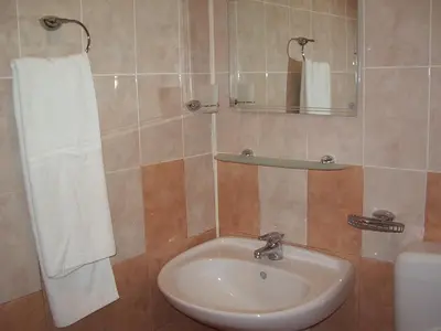 a bathroom with a sink and a mirror and a toilet at Vanessa Family Hotel in Ravda