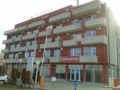 a red building with a hotel sign in front of it at Hotel Seasons 2 in Sunny Beach