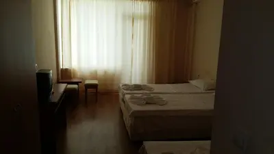 a bedroom with two beds and a television and a window at Hotel Seasons 2 in Sunny Beach