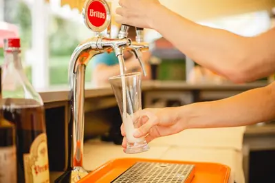 a person is washing a glass under a faucet at Deva Hotel - All Inclusive in Sunny Beach