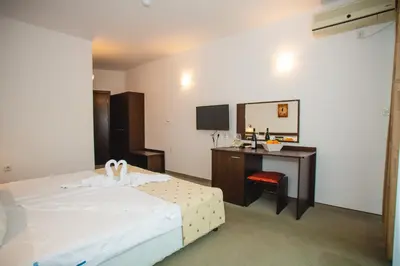 a bedroom with a bed and a desk with a mirror at Deva Hotel - All Inclusive in Sunny Beach