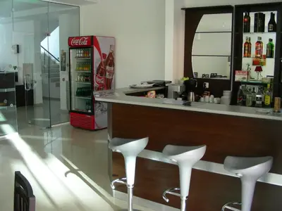 a bar with two stools and a coca cola refrigerator at Deva Hotel - All Inclusive in Sunny Beach