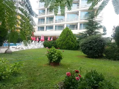 a hotel with a yard with chairs and a building at Deva Hotel - All Inclusive in Sunny Beach
