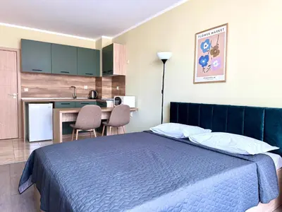a bedroom with a blue bed and a kitchen at Evi Apartments 2 in Pomorie