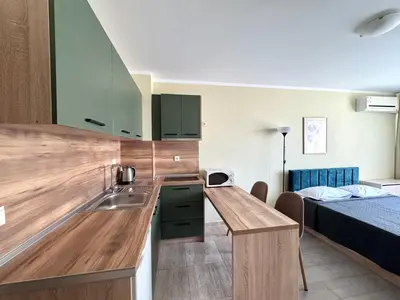 a kitchen with a sink and a bed in a room at Evi Apartments 2 in Pomorie