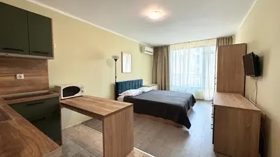 a small hotel room with a bed and a television at Evi Apartments 2 in Pomorie