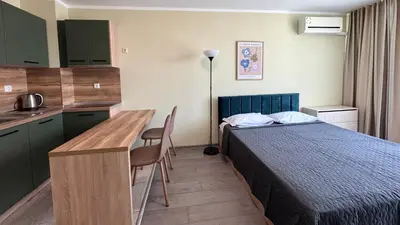 a hotel room with a bed and a desk and a kitchen at Evi Apartments 2 in Pomorie