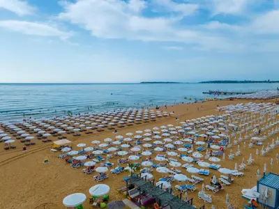 a beach with a lot of umbrellas and the ocean at MPM Hotel Orel - Ultra All Inclusive in Sunny Beach