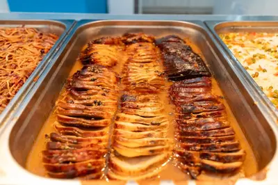 a tray of food with meat in a sauce at MPM Hotel Orel - Ultra All Inclusive in Sunny Beach