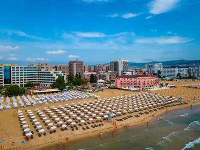 a beach with umbrellas and a crowd of people at MPM Hotel Orel - Ultra All Inclusive in Sunny Beach