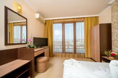 a hotel room with a bed and a mirror at Hotel Iris in Nesebar