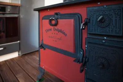 a red and black stove with the words three dwelling with aids at Three Dolphins Hotel with a Rooftop terracе in Varna City