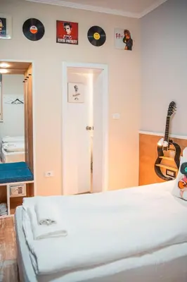 a bedroom with a bed and a guitar on the wall at Three Dolphins Hotel with a Rooftop terracе in Varna City