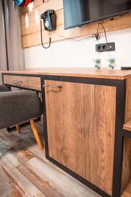 a wooden desk with a television on top of it at Three Dolphins Hotel with a Rooftop terracе in Varna City
