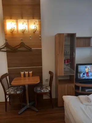 a room with a table and a tv and a bed at Three Dolphins Hotel with a Rooftop terracе in Varna City