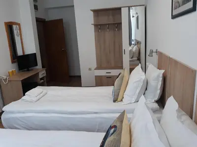 a hotel room with two beds and a television at Three Dolphins Hotel with a Rooftop terracе in Varna City