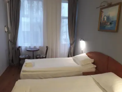 a hotel room with two beds and a window at Three Dolphins Hotel with a Rooftop terracе in Varna City