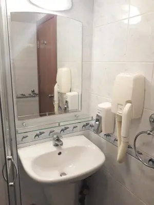 a bathroom with a sink and a mirror at Three Dolphins Hotel with a Rooftop terracе in Varna City