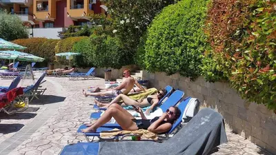 a group of people laying on lounge chairs at a resort at Relax studio by the sea, Bulgaria,Nesebar,Aheloy in Aheloy