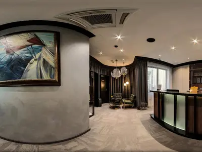 a lobby with a painting on the wall and a table at Efbet Hotel in Varna City