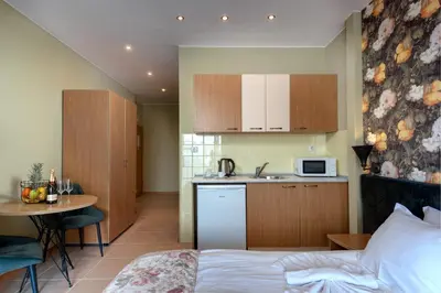 a bedroom with a bed and a kitchen with a table at Hotel Avenue in Sunny Beach