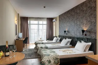 a hotel room with two beds and a couch at Hotel Avenue in Sunny Beach