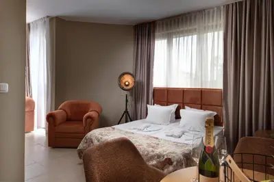 a bedroom with a bed and a chair and a table at Hotel Avenue in Sunny Beach