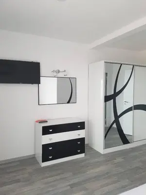 a white room with a mirror and a dresser at Guest House Evtimov in Primorsko