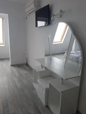 a white room with a mirror and a desk at Guest House Evtimov in Primorsko