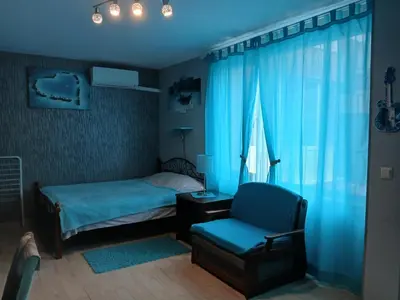 a bedroom with a bed and a chair and a window at Studio Eva 31 in Pomorie