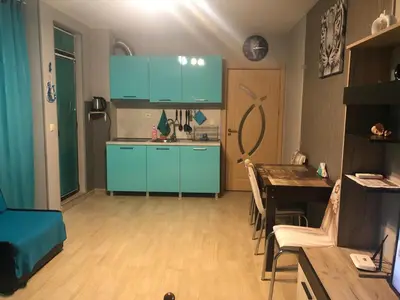 a kitchen with blue cabinets and a dining table at Studio Eva 31 in Pomorie
