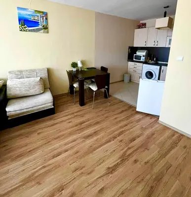 a living room with a table and a kitchen at Sirena Appartment in Sveti Vlas