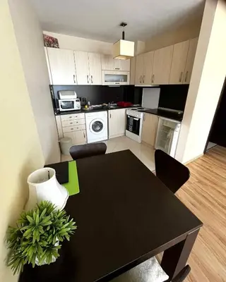 a kitchen with a black table and a dining room at Sirena Appartment in Sveti Vlas
