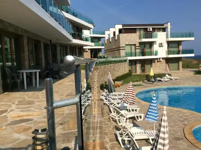 a group of lawn chairs sitting next to a swimming pool at Seaside Apartment in Sozopol
