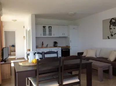 a kitchen and living room with a table and a dining room at Seaside Apartment in Sozopol